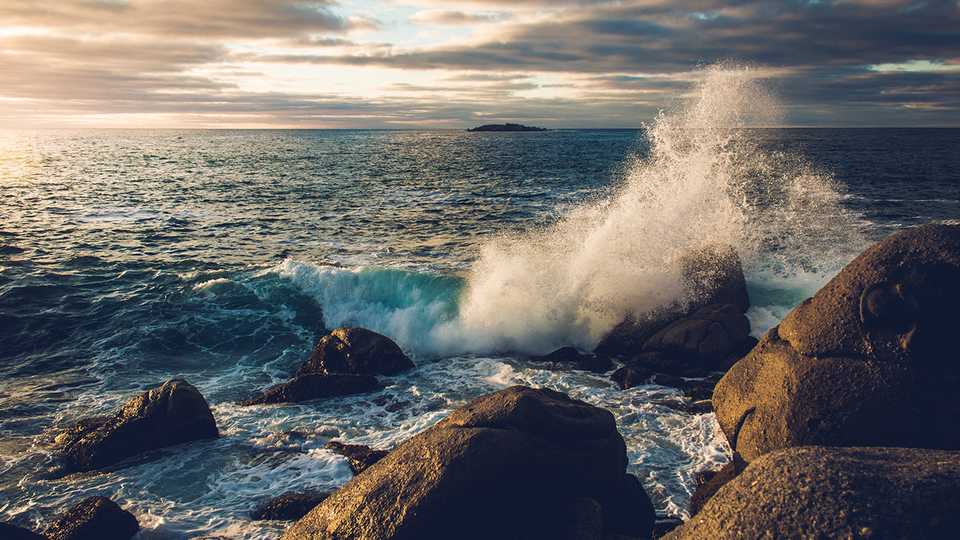 Um lindo oceano com ondas batendo nas pedras.
